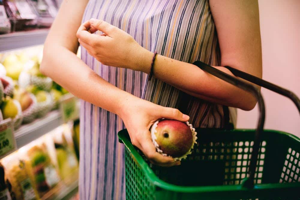 woman putting fruit into her shopping basket 