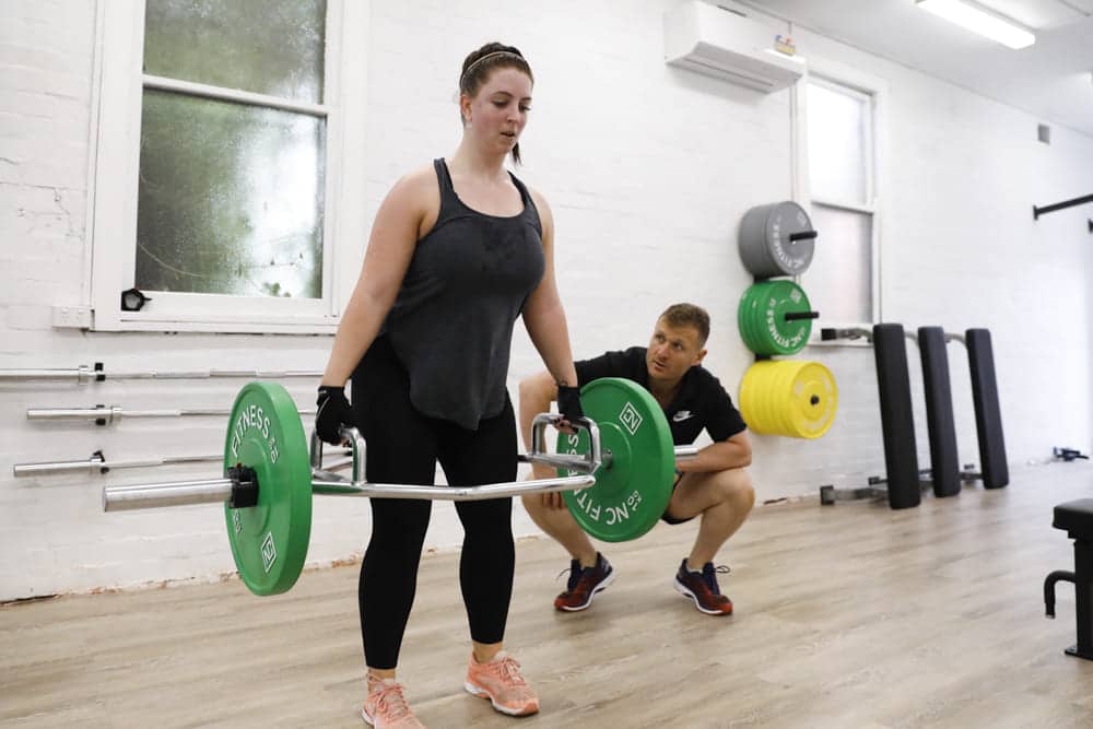 woman performing exercise with trainer