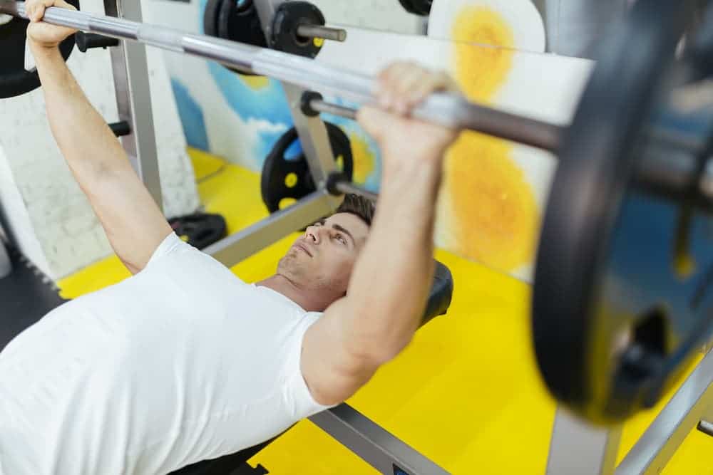 man lifting weights at gym