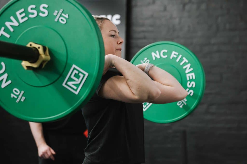 female with blonde hair holding barbell